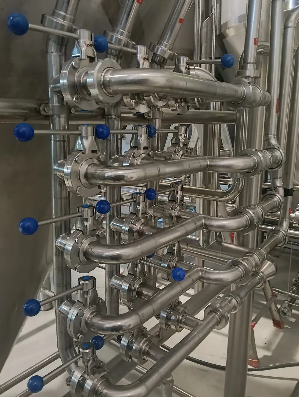 Detalle de tuberías de acero inoxidable ISOTANK con válvulas y conexiones DIN alimentarias — soldadura TIG de calidad alimentaria